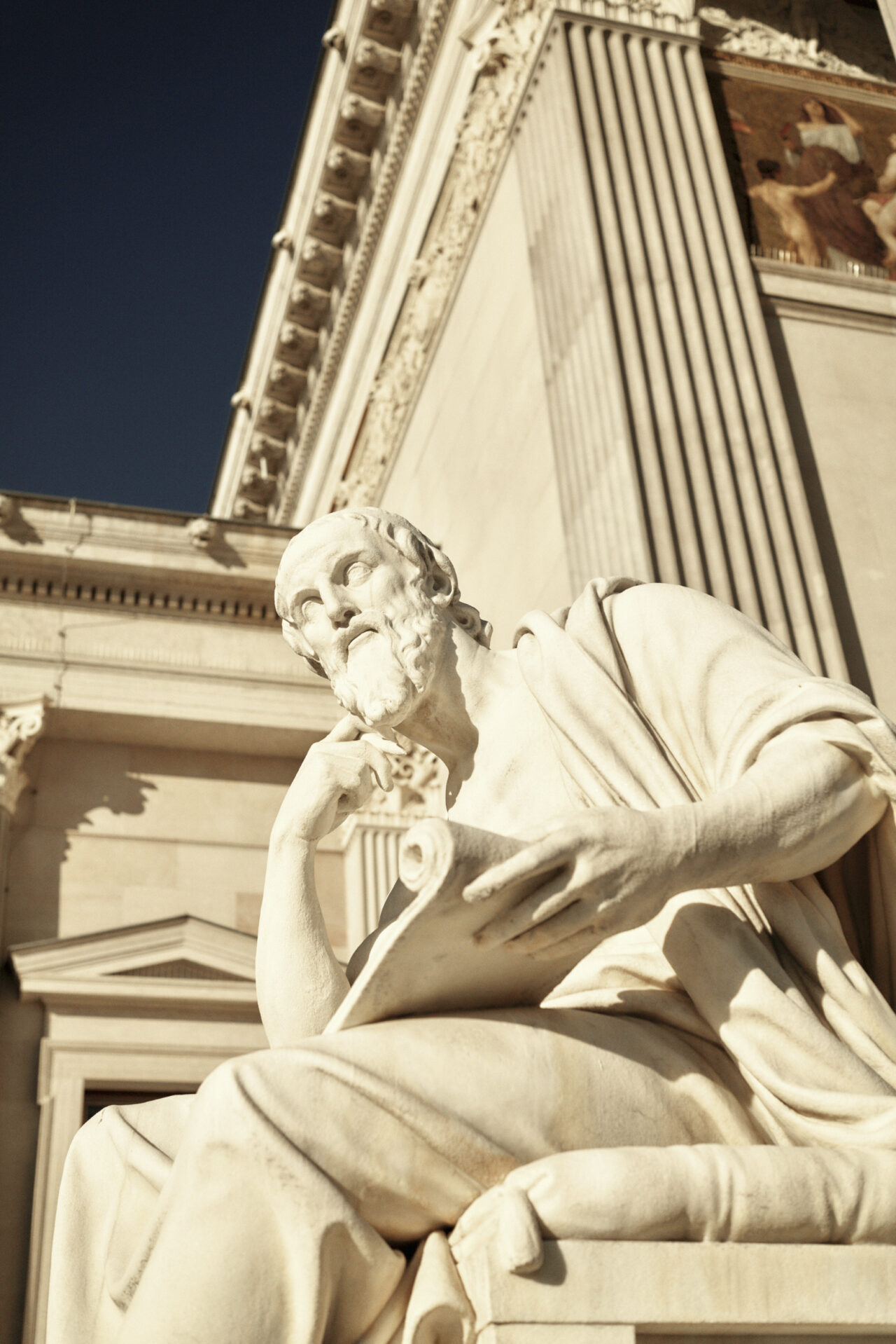 Eine Statue mit denkendem Blick vor dem wiener Parlament