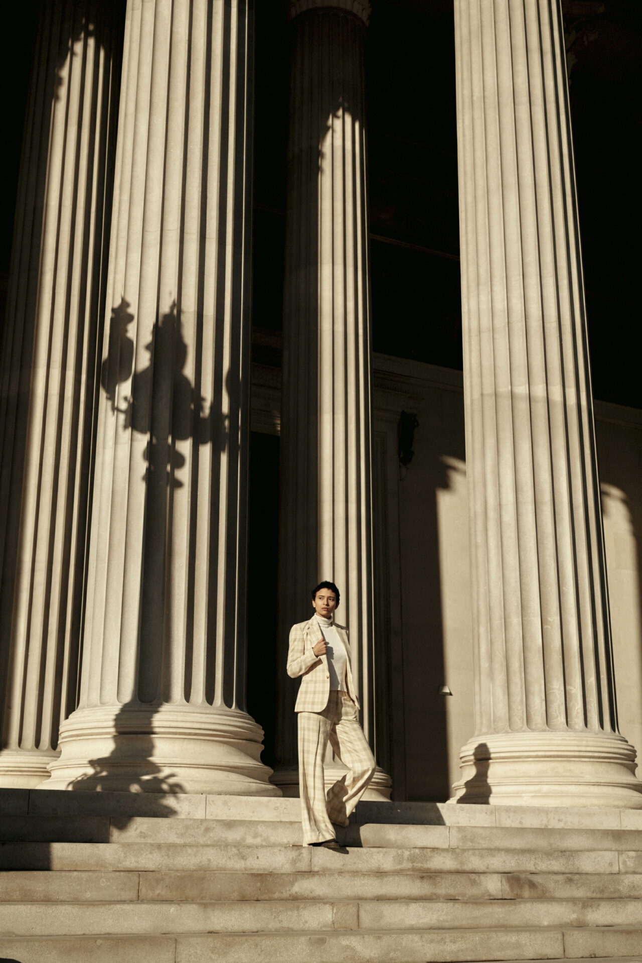 Eine Frau steht vor den Säulen des wiener Parlements