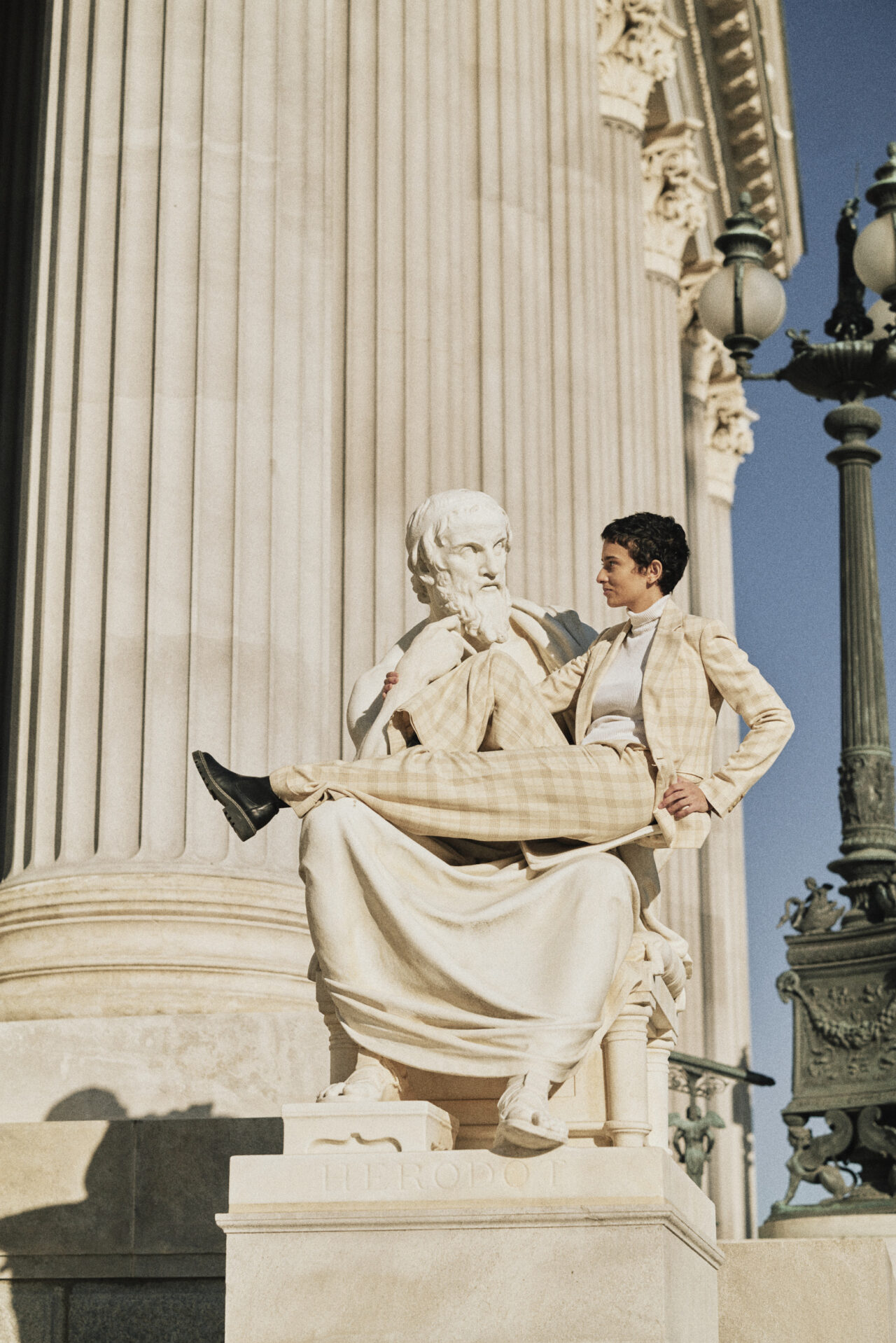 Eine Frau posiert vor einer Statue vor dem wiener Parlement