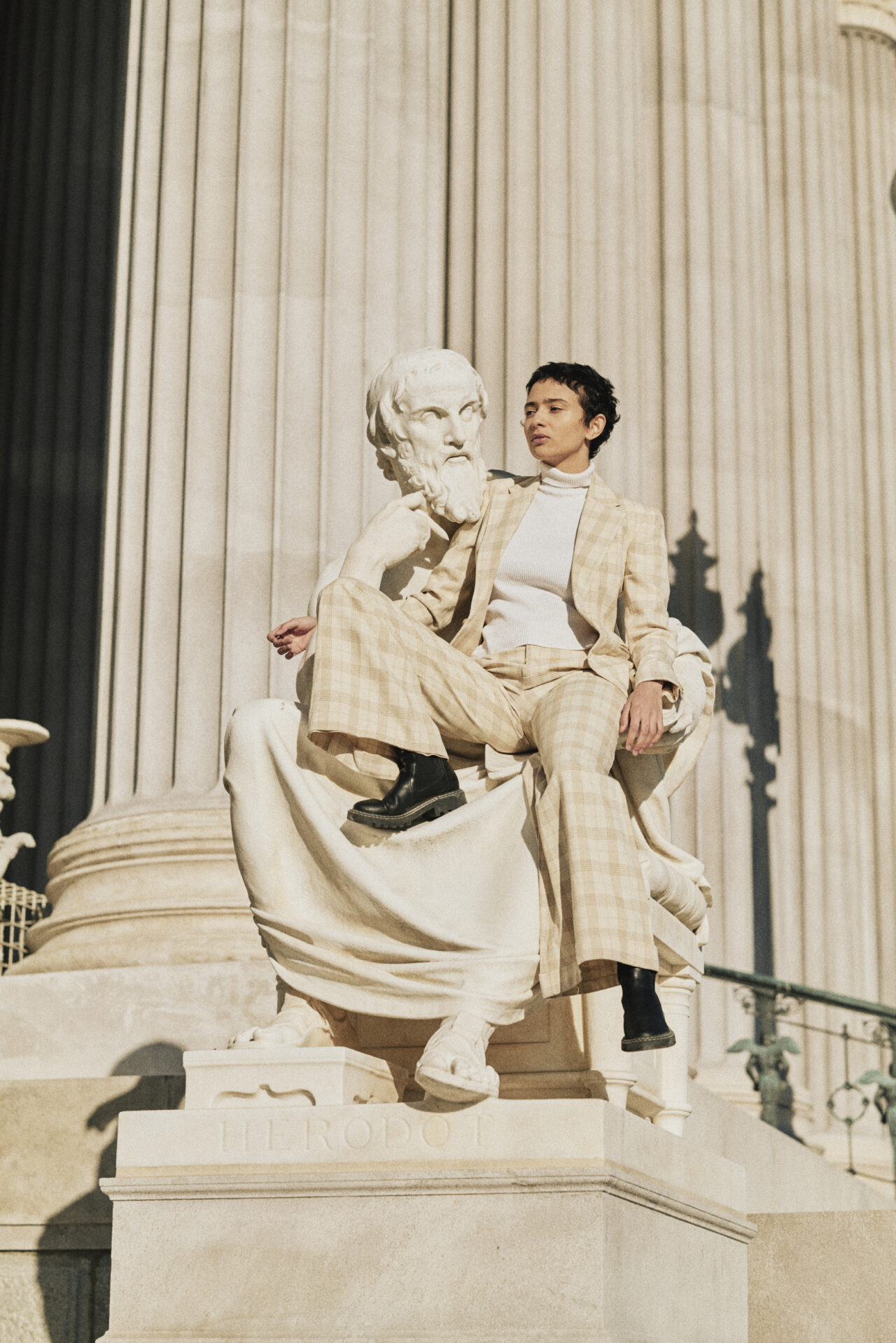 Eine Frau posiert vor einer Statue vor dem wiener Parlement